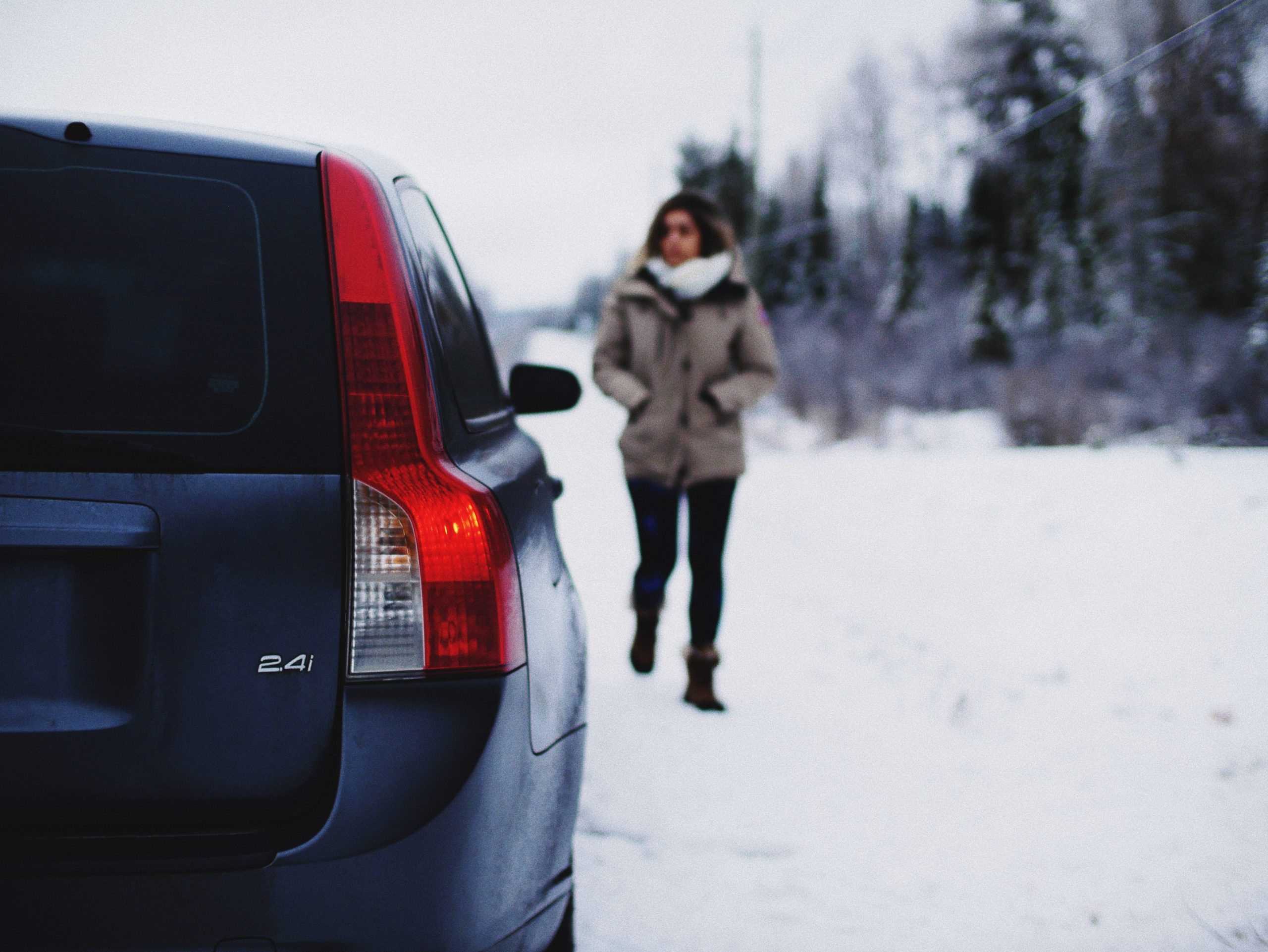 Volvo parkert, kvinne går mot bilen.