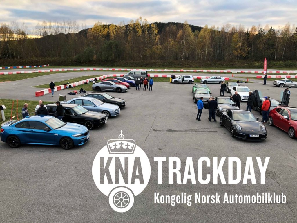 KNA Trackday på vålebanen reklamebanner, Flere biler står klare for dyst på parkeringen.