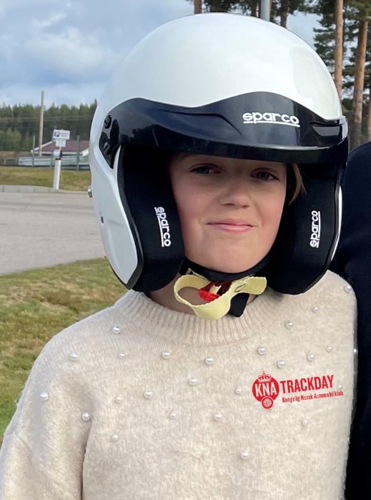 Jente med bilsporthjelm ser i kamera